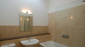 A bathroom with a toilet, sink, and bathtub. - Orchard Retreat (Sidmouth)