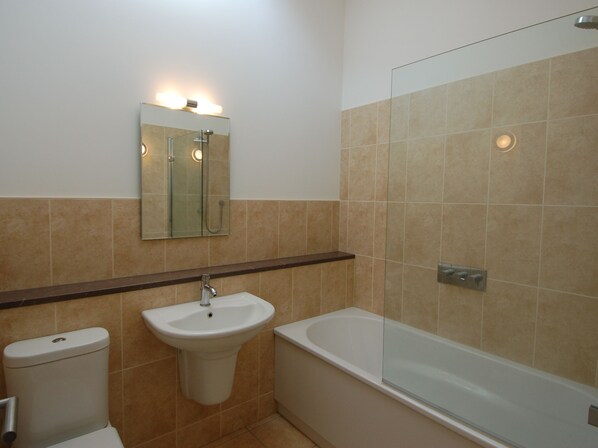 A bathroom with a toilet, sink, and bathtub.