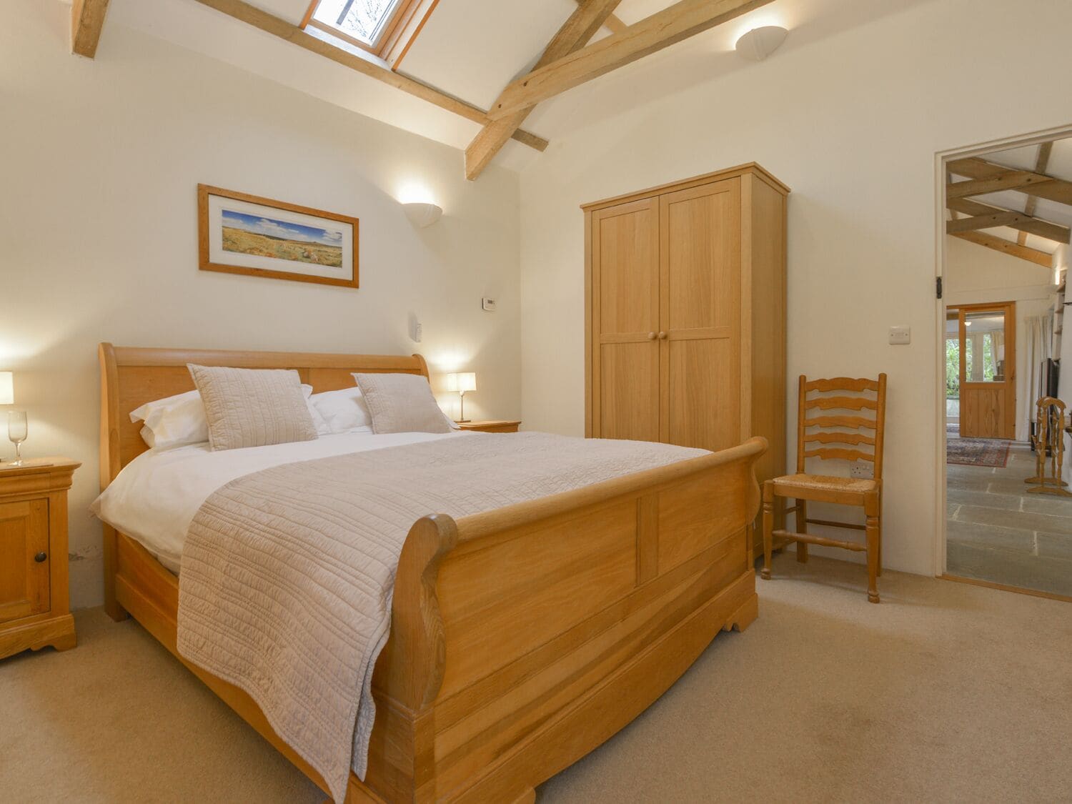 A bedroom with a wooden bed, a nightstand, a wardrobe, and a chair.