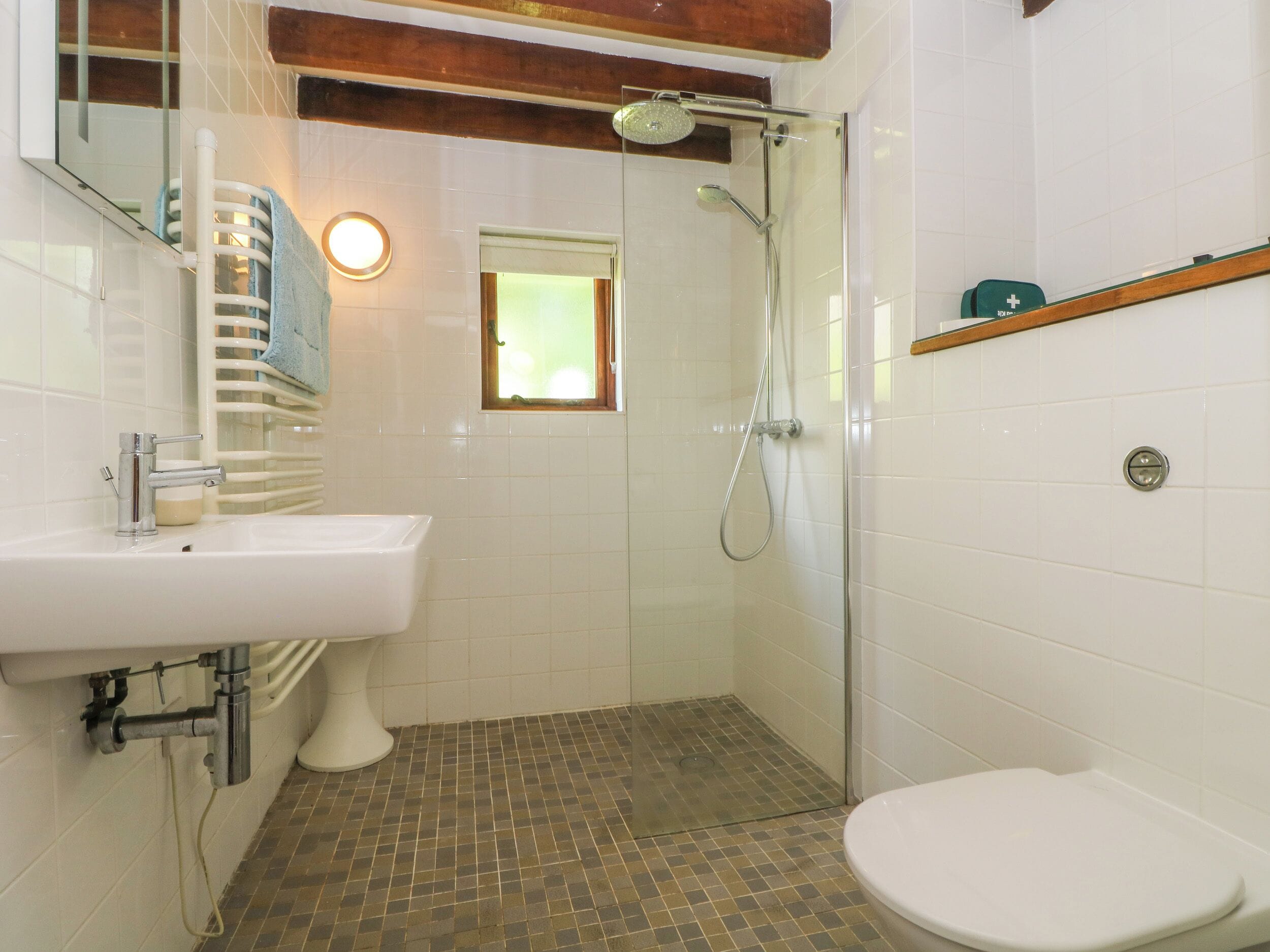 Un baño con un lavamanos blanco, un inodoro y una ducha.
