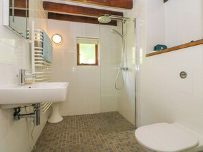 A bathroom with a white sink, a toilet, and a shower. - Oaklands (Camelford)