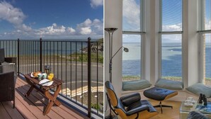 Un balcón con una mesa lista para el desayuno y vista al océano.