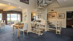 A spacious living area with a spiral staircase, a pool table, and a view of the outdoors. - Bight Boathouse (Dartmouth)