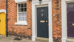 A row of three doors with different colors: yellow, dark blue, and purple. - 24 College Lane (Stratford-upon-Avon)