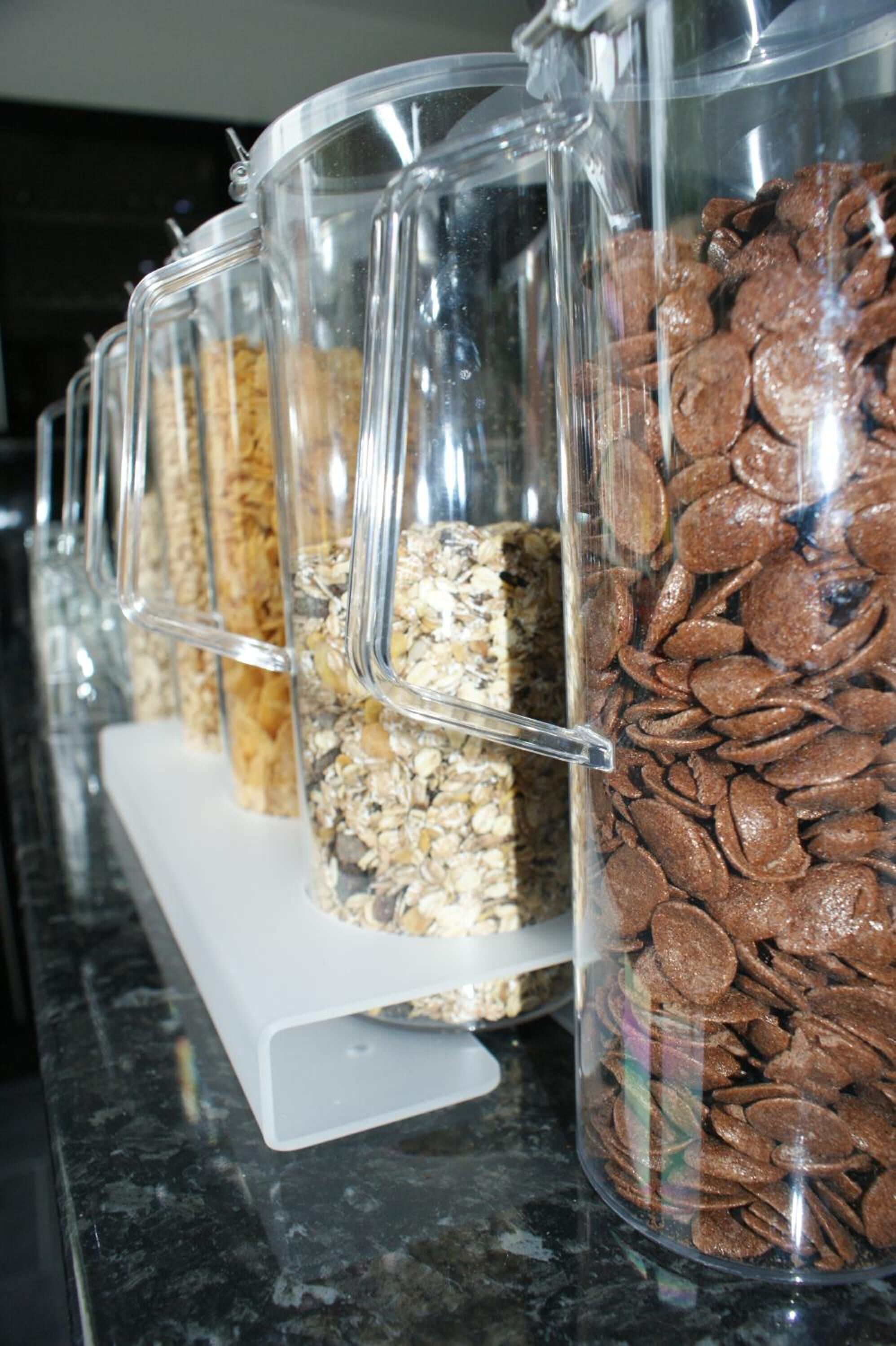 A row of clear containers with various food items on a countertop.