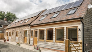 Une rangée de charmantes maisons en pierre, dotées de panneaux solaires sur le toit, de portes en bois et de grandes fenêtres.
