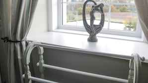 A room with a window overlooking a landscape, a white radiator, and a curtain. - Todlaw Farm House (Jedburgh)