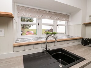 Enjoy cooking in this kitchen with a sink, window, and countertop featuring a toaster.