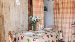 A dining table set with plates, glasses, and a vase of flowers. - The Cottage (Llangollen)