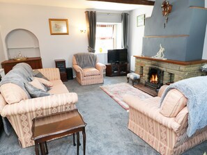 A cozy living room with a fireplace, a television, and a comfortable seating area.