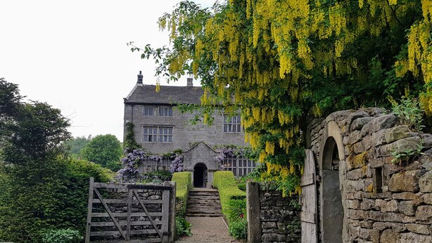 A stone building with a traditional design, featuring a stone gate and steps leading to a wooden door. - High Hall (Skipton)
