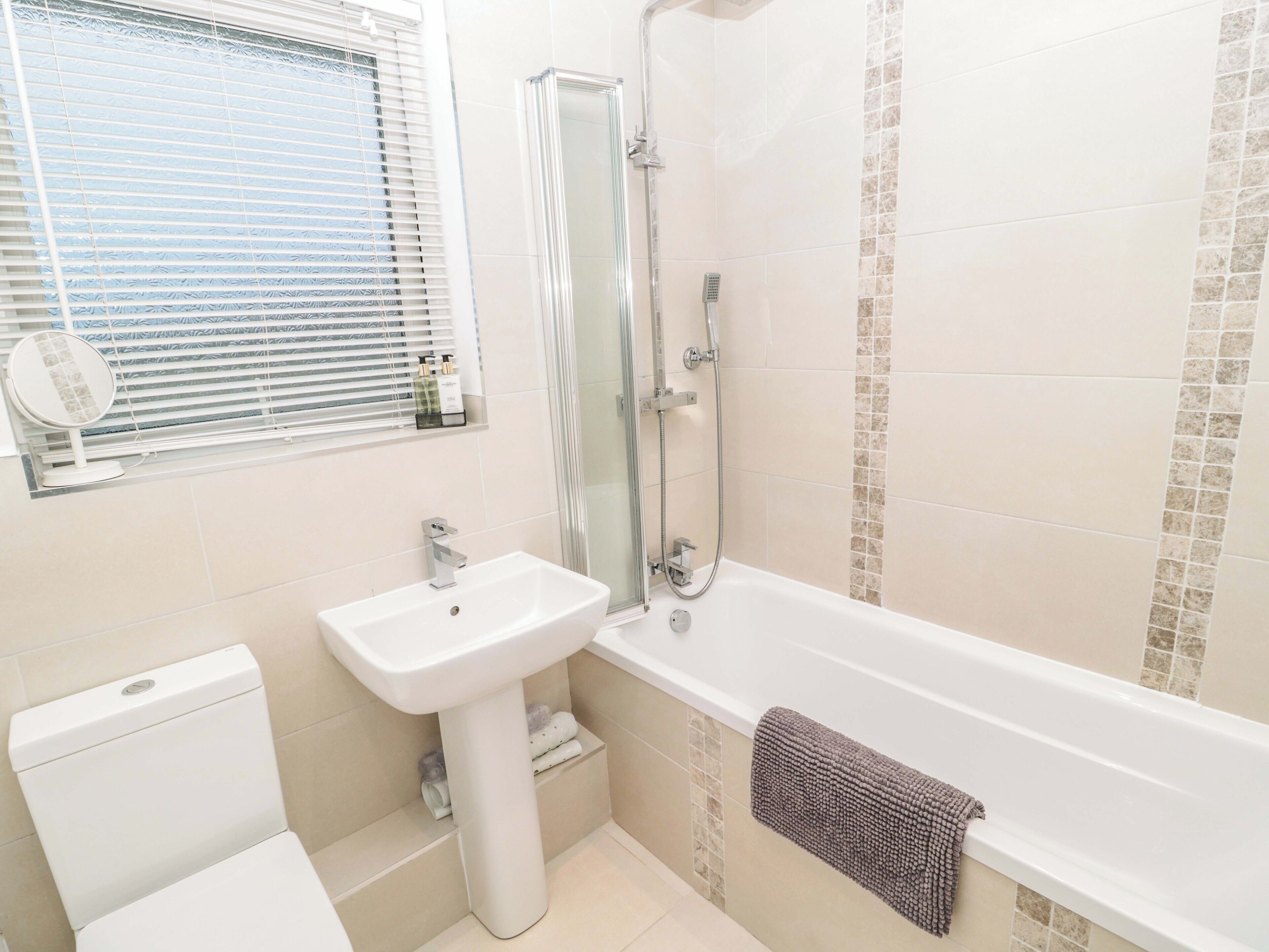 Une salle de bain comprenant des toilettes, un lavabo, une douche et un porte-serviettes.