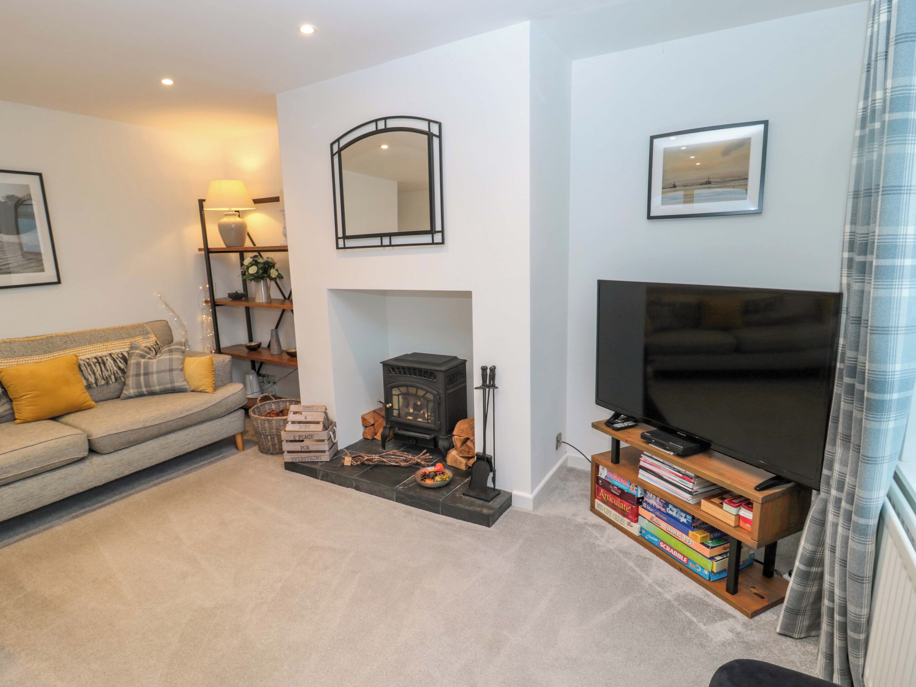 A living room with a sofa, a fireplace, a television, and a bookshelf.