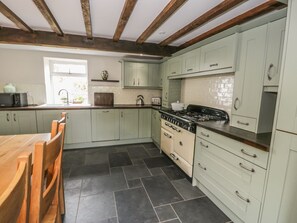 Classic kitchen with a wooden dining table, stove, oven, and appliances.