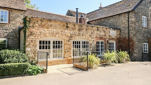 A stone building with a sign reading "Guest Reception." - Seaton (Oakham)