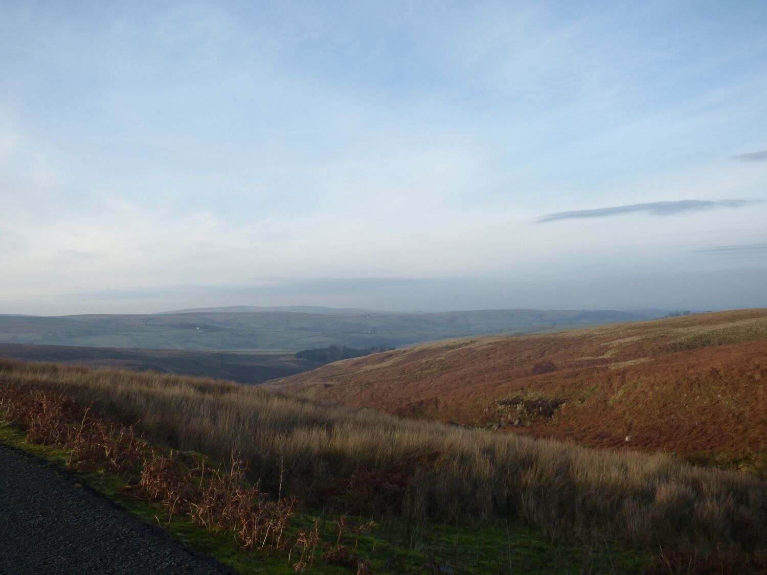 A rural landscape with rolling hills and a clear sky.