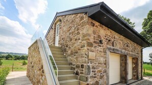 Un edificio de piedra con una escalera que conduce a una puerta con la inscripción "Deer Lodge".