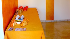 A dining area with a long table set for a meal, framed artwork on the walls, and a warm ambient light fixture. - B&B Barone (Castro)