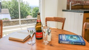 A wooden table with a book, a bottle of wine, and two glasses. - Magistrates Chambers (Carnforth)