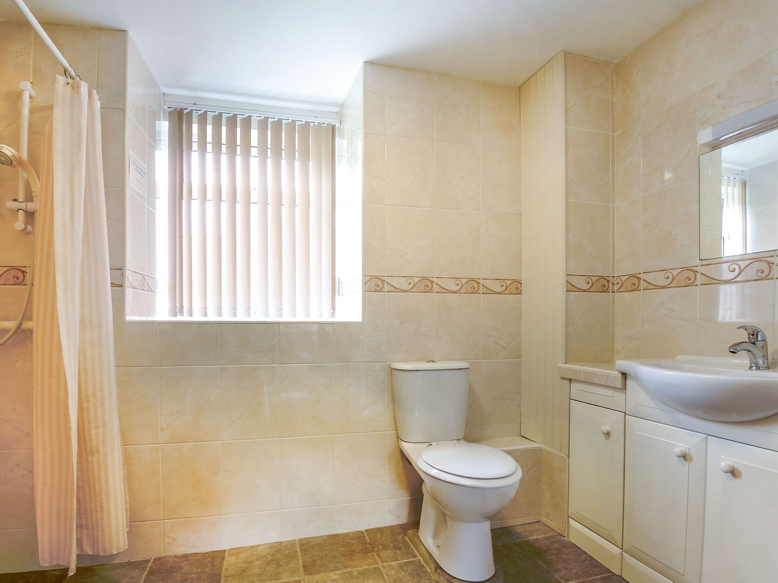 Ein Badezimmer mit Toilette, Waschbecken und Duschvorhang.