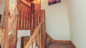 A wooden staircase with a handrail, carpeted steps, and a wall-mounted picture.