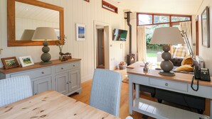 Una sala de estar acogedora con chimenea, un comedor y un espejo grande.
