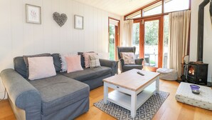 A cozy living room with a grey sofa, a white coffee table, and a fireplace. - Brooke (Oakham)
