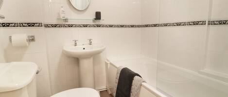 A bathroom with a toilet, sink, and bathtub.