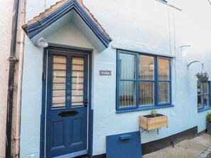 A blue-painted building with a door and windows, a nameplate reading 'Bramla', and a small wooden planter on the ground. - Bramla (Saltburn-by-the-Sea)