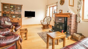 Ein gemütliches Wohnzimmer mit Ledersessel, Holztisch und Kamin.