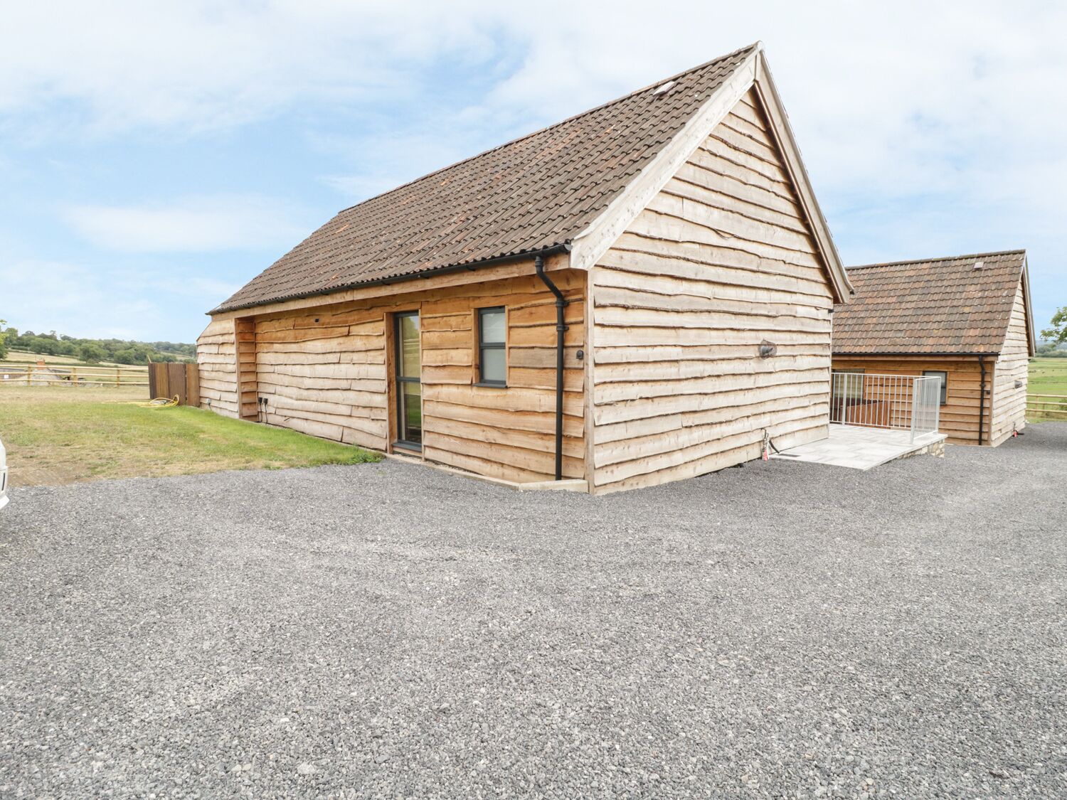 A wooden cabin with a sloped roof, a front door, and a small porch area.