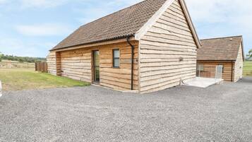 A wooden cabin with a sloped roof, a front door, and a small porch area.