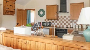 Une cuisine avec des meubles en bois, un four à micro-ondes, une cuisinière et un évier.