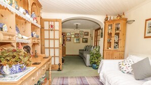 A cozy room with a bed, a wooden cabinet, and a dining table with a vase of flowers.