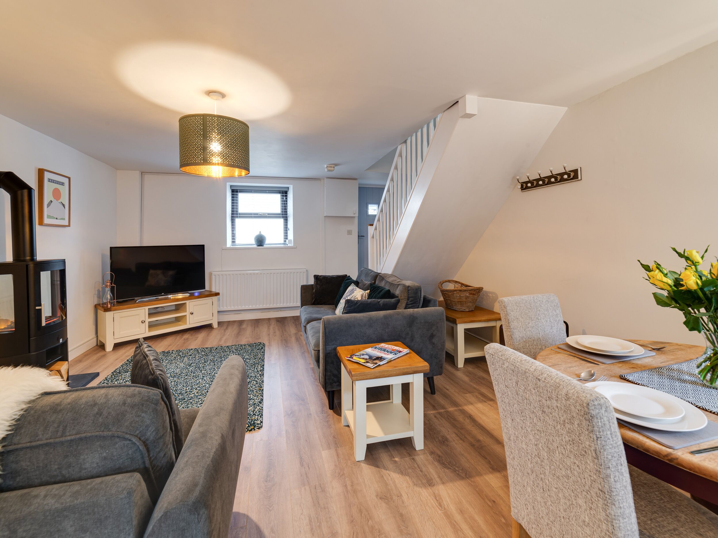 A modern living room with a TV, sofa, and dining area.