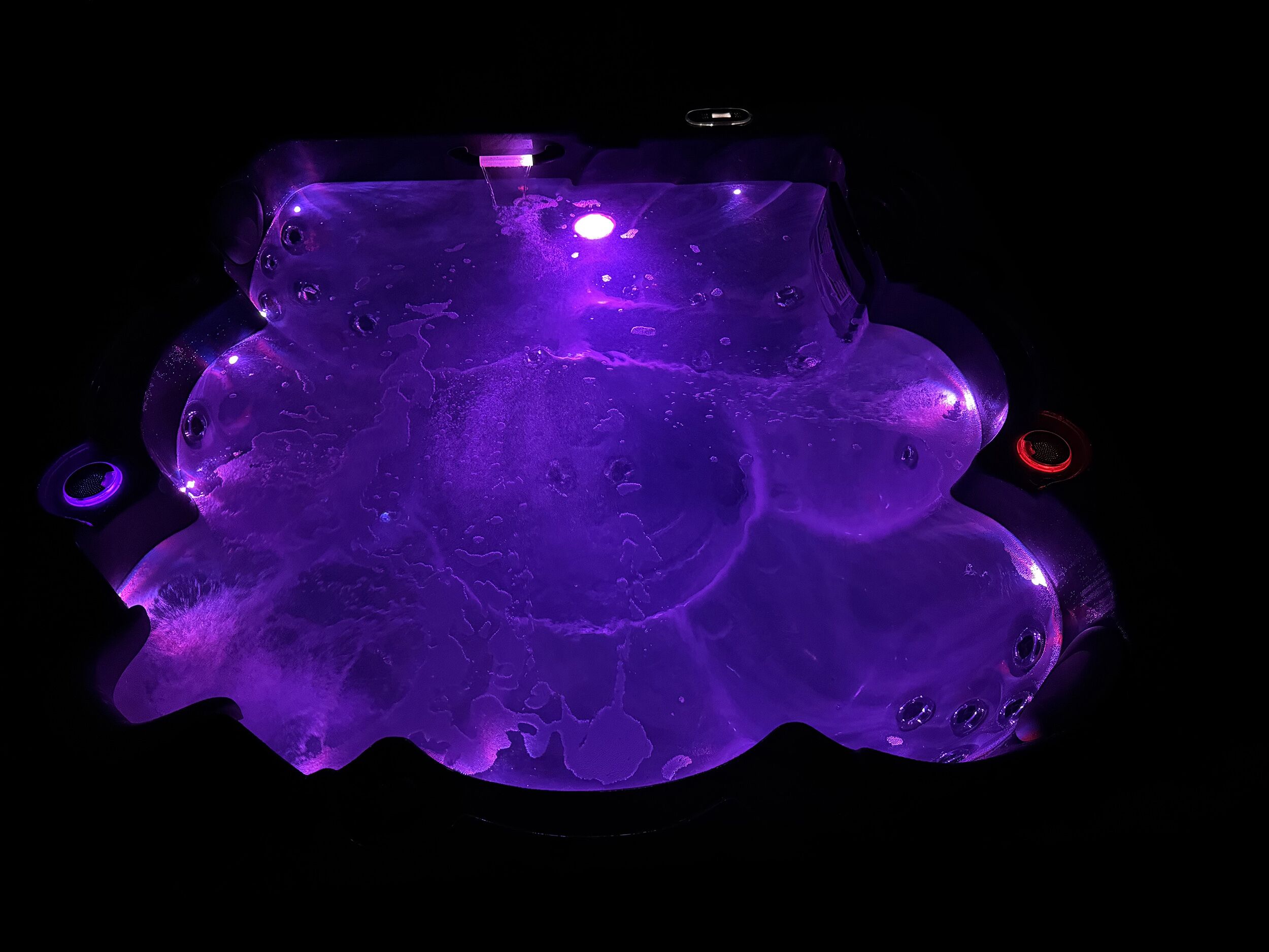Une pièce dans laquelle se trouve un grand objet sphérique, de couleur violette et illuminé, placé au centre, qui pourrait être un élément décoratif ou une sculpture.