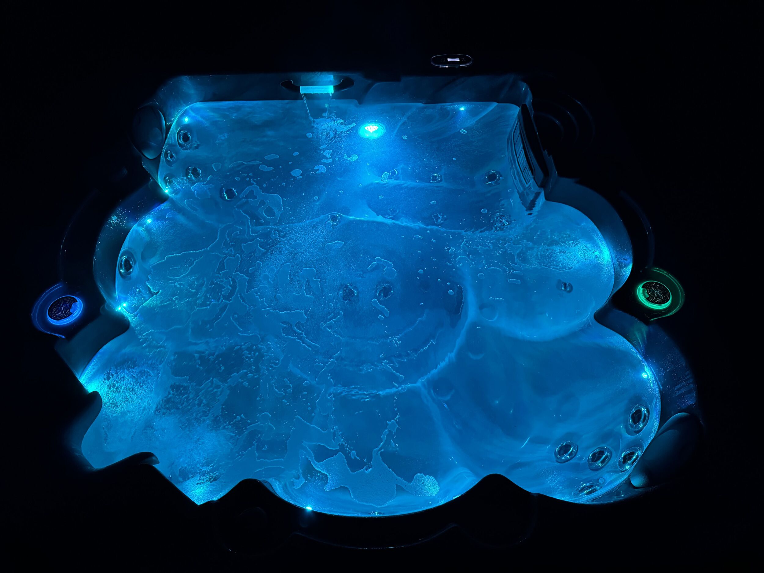 A hot tub with multiple jets and a control panel.