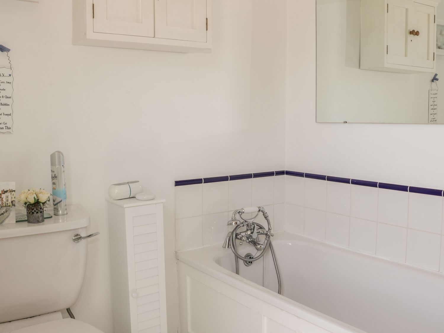 Un baño con bañera, inodoro y espejo.