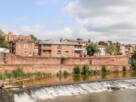 A historic brick building with a water feature in front.