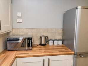 A kitchen with a built-in toaster, kettle, and three spice containers labeled sugar, tea, and coffee. - 11A Church Street (Whitby)