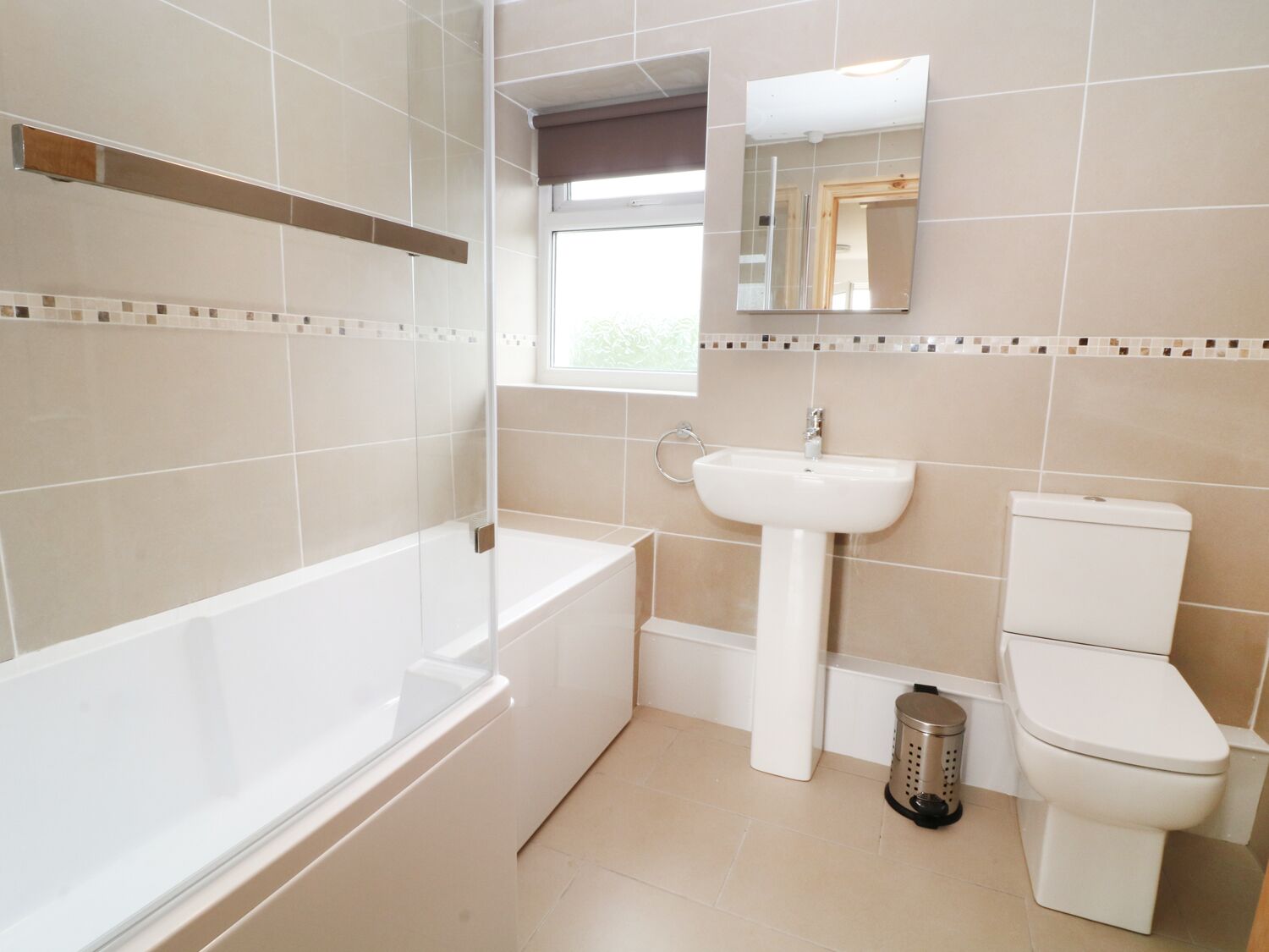 A modern bathroom with a bathtub, sink, and toilet.