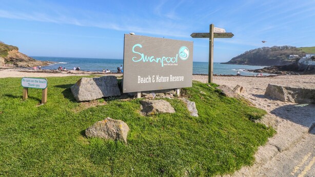 Un panneau indiquant l'accès à la « plage de Swampland et à la réserve naturelle », avec un autre panneau interdisant l'accès aux voitures sur la plage.
