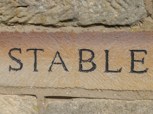 Una pared de piedra con la palabra "STABLE" grabada.