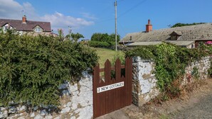 Un cancello conduce a una proprietà con l'indicazione '2 NEW COTTAGES'.