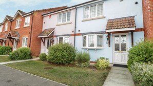 A row of terraced houses with a well-maintained lawn and a clear pathway leading to the entrance.