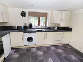 A compact kitchen with a washing machine, a toaster, and a sink.