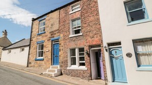 A two-story building with a brick facade and blue-framed windows. - Clevelyn (Saltburn-by-the-Sea)