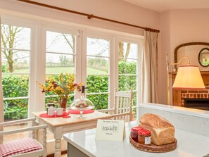 Una habitación acogedora con una mesa preparada para el desayuno, que incluye pan, mermelada y una tarjeta de menú.