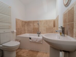 Une salle de bain comprenant des toilettes, une baignoire et un lavabo.