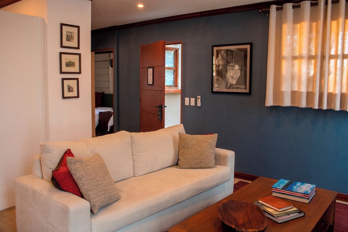 A living room with a sofa, a coffee table, and a bookshelf.